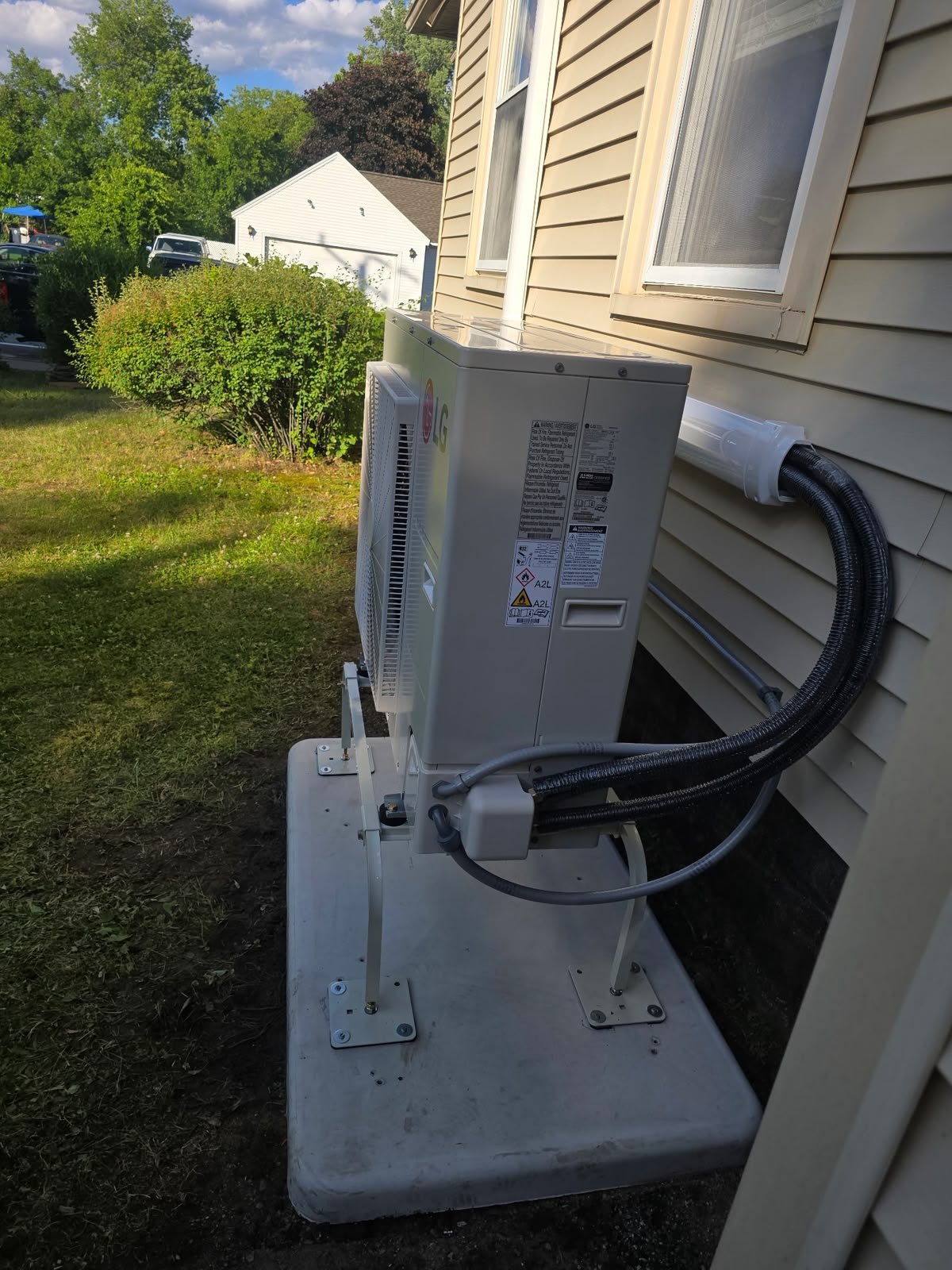 Outdoor ductless heating and cooling unit beside a home